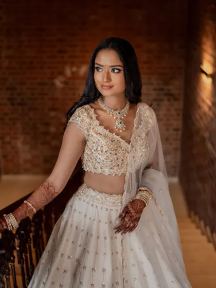 The bride looking serene and elegant in her white lehenga for her engagement. The venue's architecture and our decor choices provide a stunning backdrop for her portraits.