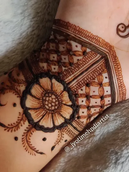 Another angle of the peacock and floral cuff, focusing on the intricate floral and geometric work on the wrist.