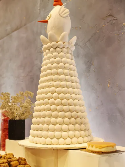 A whimsical macaron tower, topped with a charming bird figurine. This kind of large-scale dessert sculpture serves as a stunning centerpiece for any celebration.