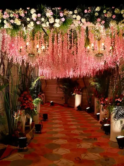 Another perspective of a grand floral entrance, this time with a patterned carpet and elegant gates. The dense canopy of hanging pink wisteria creates a truly immersive and romantic welcome.