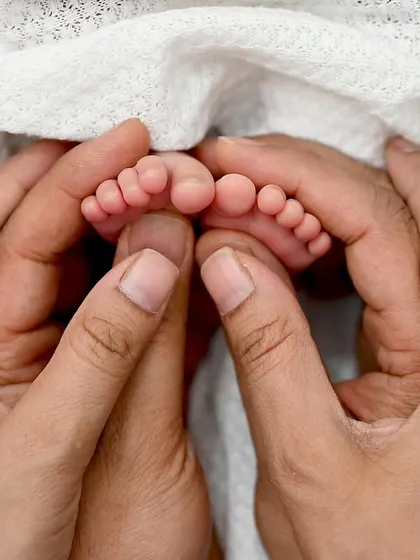 The whole world in their hands. This close-up of a newborn's tiny feet held gently by mom and dad is a powerful reminder of how small they start. These are the details you will want to remember forever.
