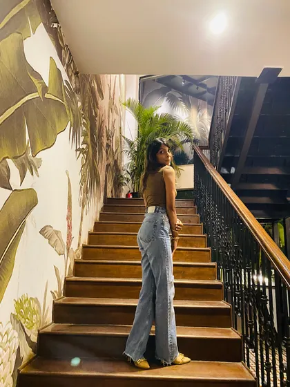 Slaying on the stairs in a brown tank top and wide-leg jeans. This shows how even the most basic pieces can look fashionable with the right fit and confidence.