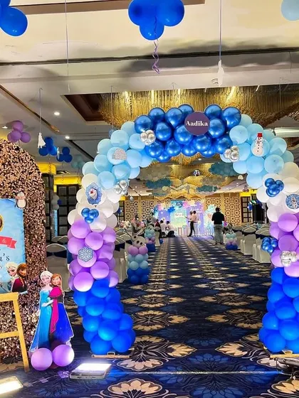 A grand entrance for a 'Frozen' first birthday, with a long balloon archway leading into the party hall, setting a magical winter tone.