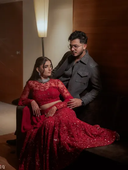 A moody and romantic portrait of the couple on their Sangeet night, dressed in stunning red and grey ensembles.