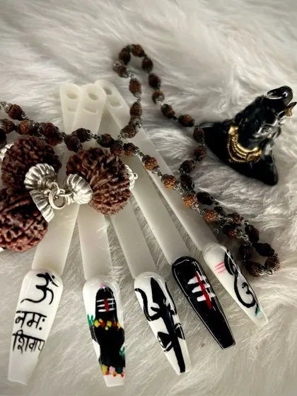 Artistry knows no bounds. This intricate nail art set is inspired by the divine power of Mahadev, featuring detailed symbols like the Trishul and Om script, showcasing our artists' precision.