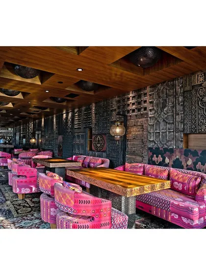 Another angle of the restaurant's interior, showing the detailed wall panels and custom furniture. This shot provides a comprehensive view of the space, emphasizing the unique textures and patterns of the decor.