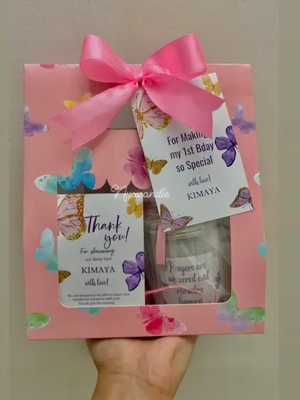 A beautiful butterfly-themed gift box for a first birthday. The pink packaging is adorned with custom tags and filled with delightful favors for the little guests.