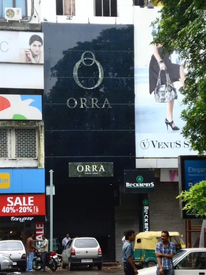 To create a strong brand identity for ORRA amidst a chaotic streetscape, we designed a silent, all-black glass facade. This minimalist approach stands in direct contrast to the surrounding environment, creating a sense of mystery and luxury that draws customers in.