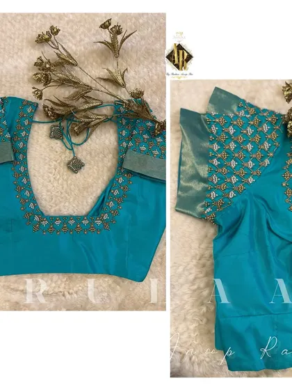 A teal blue blouse with a simple buti pattern on the sleeves. The neckline is highlighted with a delicate border, making it a versatile piece for many occasions.