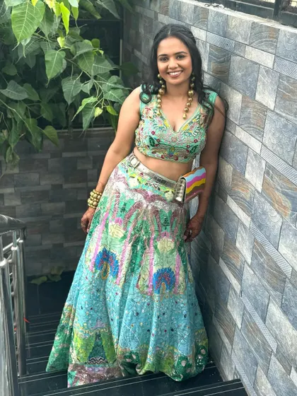 A fusion look for this wedding guest. Her unique, colorful lehenga is paired with soft curls and glowing makeup.