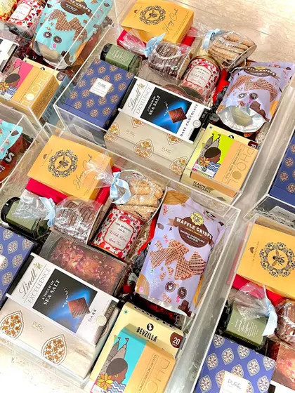 A stunning display of multiple luxury acrylic trunks, each packed to the brim with a curated selection of over a dozen premium products. This showcases our capability to deliver high-end, complex hampers at scale for special events.