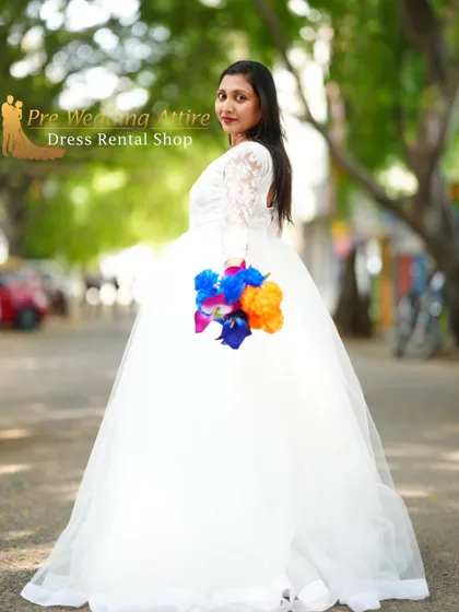 A side profile of the white ball gown, showing the lace sleeve detail and the flow of the skirt.