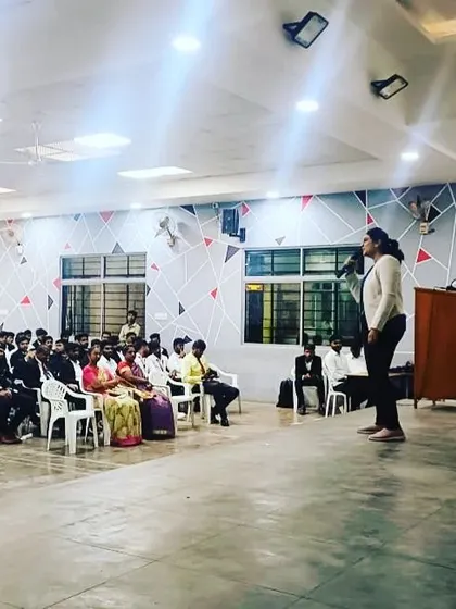Addressing a hall full of students and young adults about common dermatological issues they face.