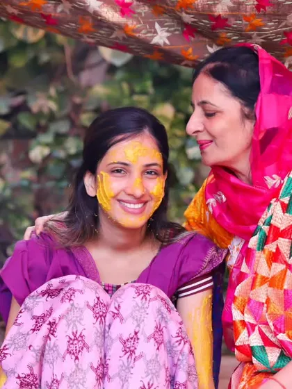A happy and colourful portrait of a bride and her mother at the Haldi. The vibrant phulkari dupatta adds a beautiful touch to this joyful photo.