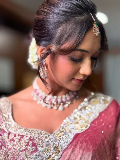 A close-up of Monica's gorgeous makeup for her event. The look features a soft pink and brown eyeshadow blend with a winged liner, paired with a beautiful ruby and diamond necklace.