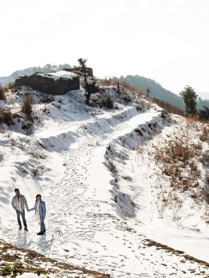 A wide-angle shot showing the couple walking together through the vast, snowy landscape. This image emphasizes their journey together, with their footprints marking the path they are forging as one.