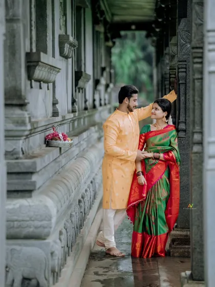 A classic pre-wedding portrait in a temple corridor. The groom gently adjusts the bride's hair, a small, intimate gesture I love to capture.