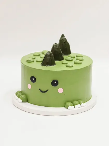 A straight-on view of the cute dino cake.