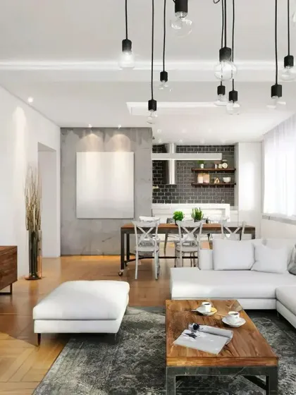 An open-plan living and dining area with an industrial-chic vibe. We used a mix of materials like concrete, wood, and metal, with exposed bulb lighting to complete the look.