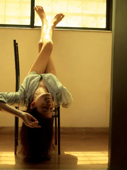 An artistic and playful shot of me hanging upside down from a chair, showing my creative and unconventional side.