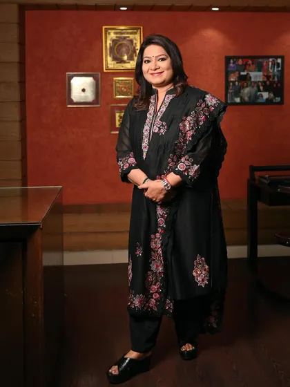 A full-length standing portrait of Mrs. Prasad. This showcases her complete look and confident stance, offering a versatile option for press features or website profiles.