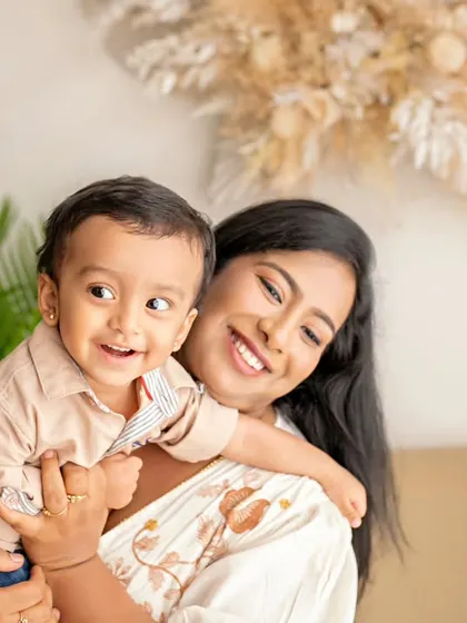 A mother holds her son close, both beaming with happiness. This portrait is a perfect example of capturing the boundless love and affection between a parent and child.