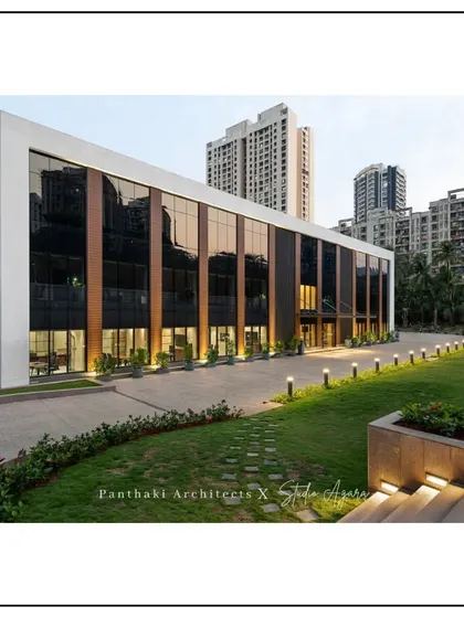 The exterior of a modern office building we designed in collaboration with Studio Agara. The facade combines glass, wood paneling, and clean white forms, with landscape lighting that enhances its appearance after dark.