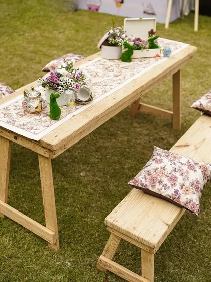Rustic picnic-style seating with wooden benches and floral cushions, offering a more casual and intimate seating arrangement.