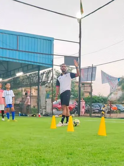 A coach gives a thumbs-up, encouraging the players during a training session. Positive reinforcement helps build confidence and motivation.