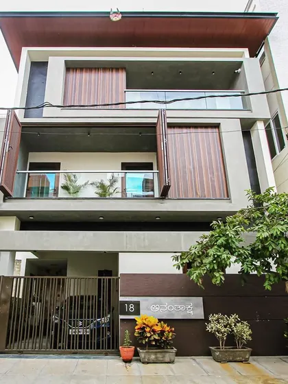 The 'Ananthaksha' residence, with its unique facade featuring large, foldable wooden shutters that allow for flexible control of light and privacy.