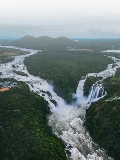 The Kaveri river splits to form the majestic Shivanasamudra falls. This aerial perspective shows the sheer scale of this natural wonder in the Mandya district.