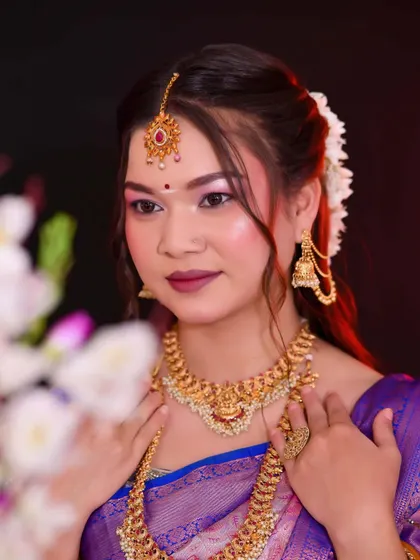 A beautiful shot of the bride surrounded by flowers. Her makeup is soft and dewy, with a focus on enhancing her natural features to match the fresh, floral theme.