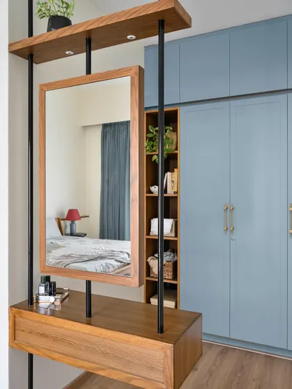 The daughter's bedroom in 'House of Kismish' features a clever vanity mirror that also acts as a partition for the wardrobe. The blue wardrobe and wooden furniture create a modern Indian vibe.