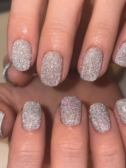 A full-coverage, dazzling silver glitter manicure. This light-reflective polish creates an incredible disco-ball effect on the nails.