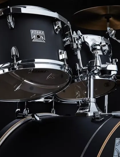 A detailed shot of the limited edition Tama Superstar Classic kit in a flat black finish, showcasing its 100% maple shells for rich, resonant tones.