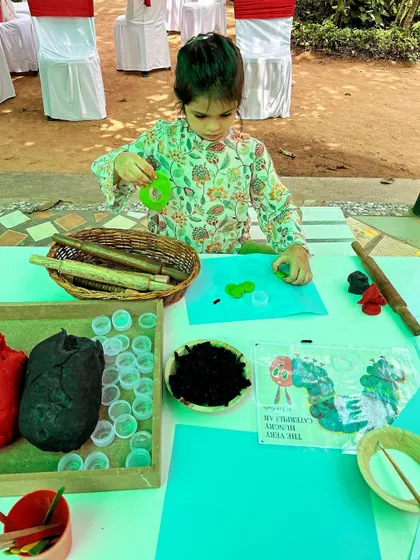 Inspired by "The Very Hungry Caterpillar," this child is using homemade playdough and natural materials to create their own caterpillar. This activity is great for storytelling and fine motor practice.
