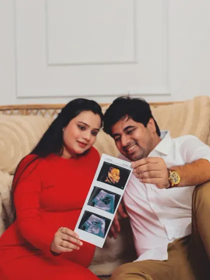 The first family photo. This couple looks lovingly at their baby's ultrasound scan pictures, a precious prop that makes their maternity shoot deeply personal.