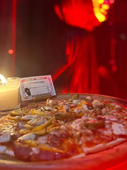 Our "Witches' Pizza" was a hit at the Halloween bash, served in a room with dramatic red lighting to enhance the spooky atmosphere.