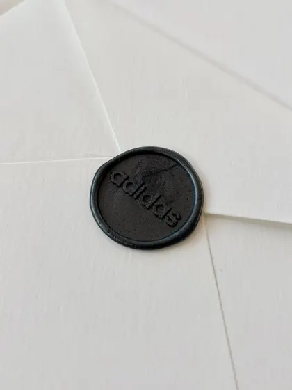 The finishing touches for the Adidas project. Each personalized certificate was enclosed in a subtly textured white envelope, carefully addressed with a brush pen, and sealed with a dark grey custom Adidas wax seal.