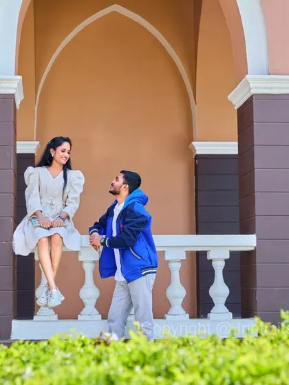 A relaxed portrait on a balustrade, showcasing a modern architectural backdrop for a stylish and informal pre-wedding look.