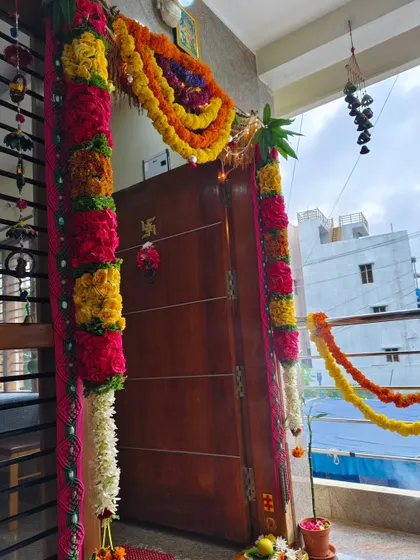 A simple yet beautiful entrance door decoration for a home ceremony. The mix of colors and the mango leaf at the top are traditional elements for an auspicious start.