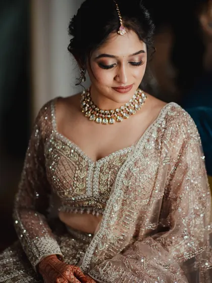 A close-up of a bride's reception makeup. This look features a soft, brown smokey eye and a neutral-toned lipstick, creating a sophisticated and modern feel.