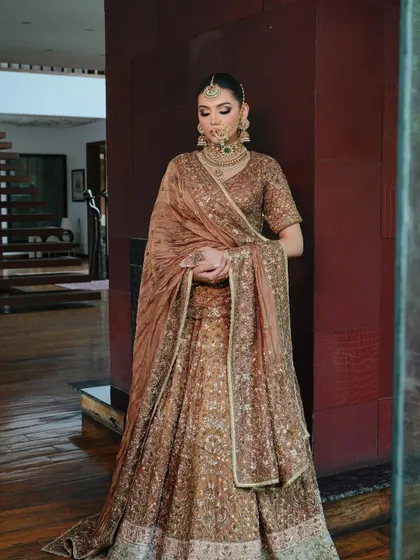 Royalty redefined. This look is all about the luxurious drape of the velvet dupatta over a heavily embellished bronze lehenga. My draping technique creates a sense of effortless elegance and grandeur.