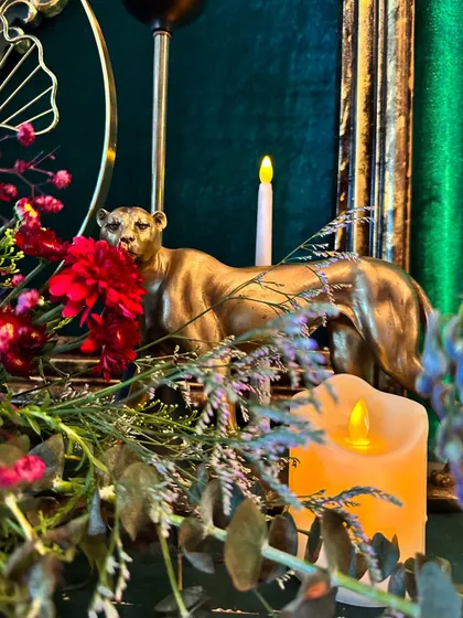 A golden tiger figurine rests among flowers and candles, a small but powerful detail that adds a touch of wild royalty to the decor.