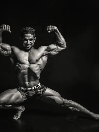 Another look at a classic pose in a dramatic black and white format, emphasizing the shadows and highlights of a well-defined musculature. This is the art and science of bodybuilding.