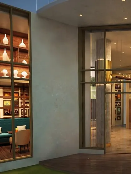 An exterior view looking into the M3M Golf Estate cafe. The design ensures the inviting atmosphere is visible from the outside, with large windows showcasing the warm interior and elegant decor.