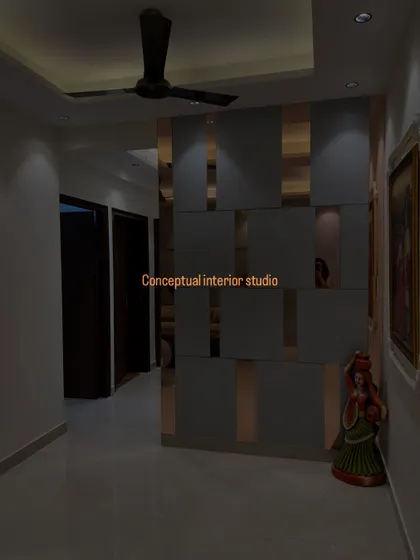A stylish partition wall made of grey panels and rose-gold mirror strips. It separates the space while also serving as a beautiful decorative feature.