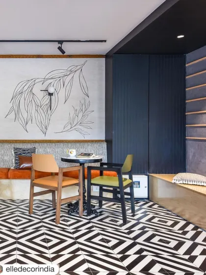 A casual meeting spot with custom wall art and mixed seating. The black and white geometric flooring continues here, tying the different zones of the coworking space together with a consistent, bold design language.