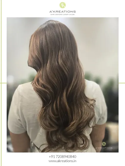 Another view of our honey blonde balayage, showcasing the soft waves and seamless blend of colors.