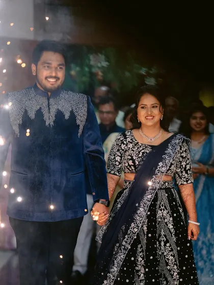 The grand entrance of the couple at their reception. The bride looks stunning in her embellished black lehenga.